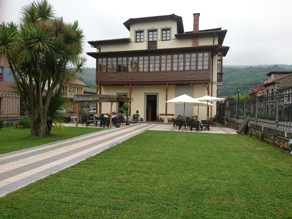 a large house with tables and chairs in front of it at Don Felix Hotel in Ríoseco