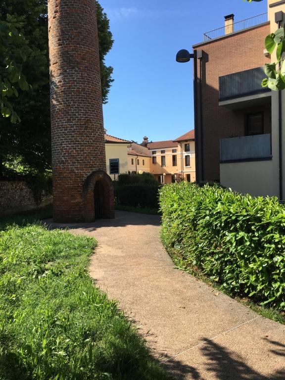 una torre de ladrillo junto a un edificio con una acera en Vecchia Filanda, en Thiene