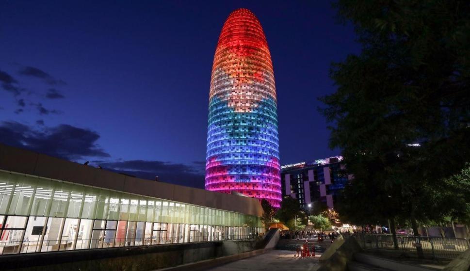 a tall building is lit up in red and blue at Good-Apartments Barcelona in Barcelona