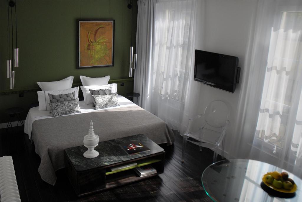 1 dormitorio con cama, mesa y TV en The Sleeping Lion, en París