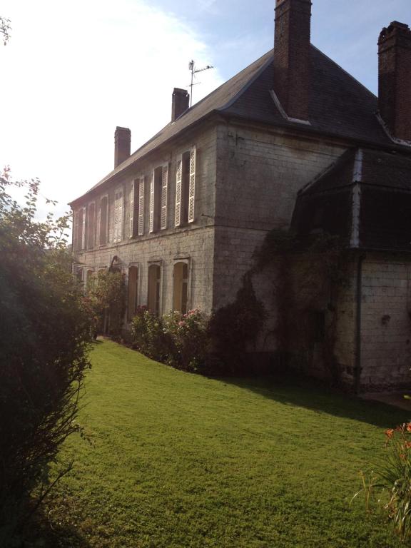 an old brick house with a grass yard in front of it at Château de Ricquebourg in Maresquel