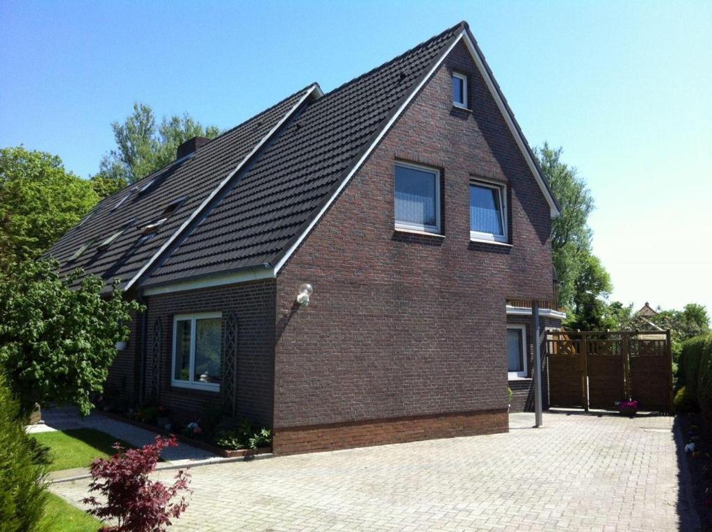 a brown brick house with a black roof at Ferienwohnung-Marita in Carolinensiel