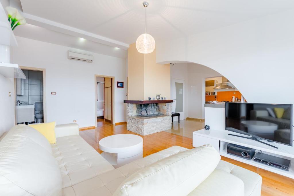 sala de estar con sofá blanco y chimenea en Apartments Flor de Lis en Podstrana