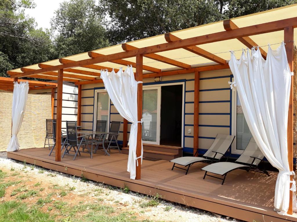 ein Haus mit Markisen und Stühlen auf einer Terrasse in der Unterkunft Grand Veles camp in Pula