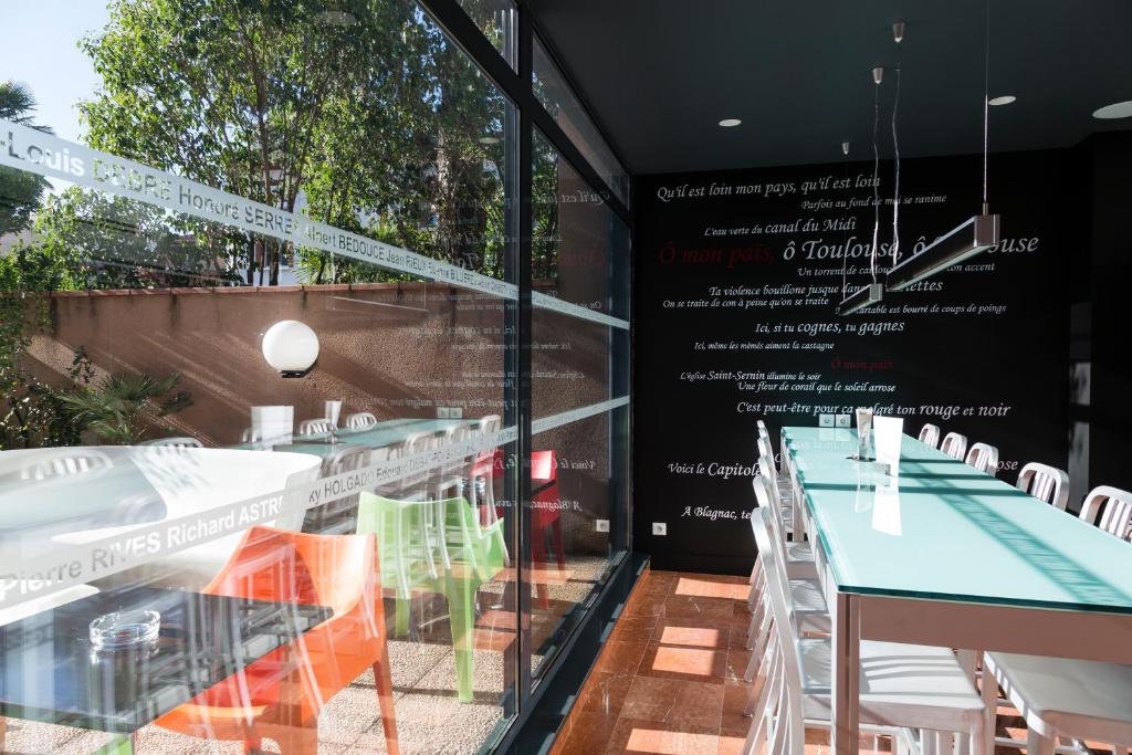 a restaurant with tables and chairs in front of a window at Hôtel de Brienne in Toulouse