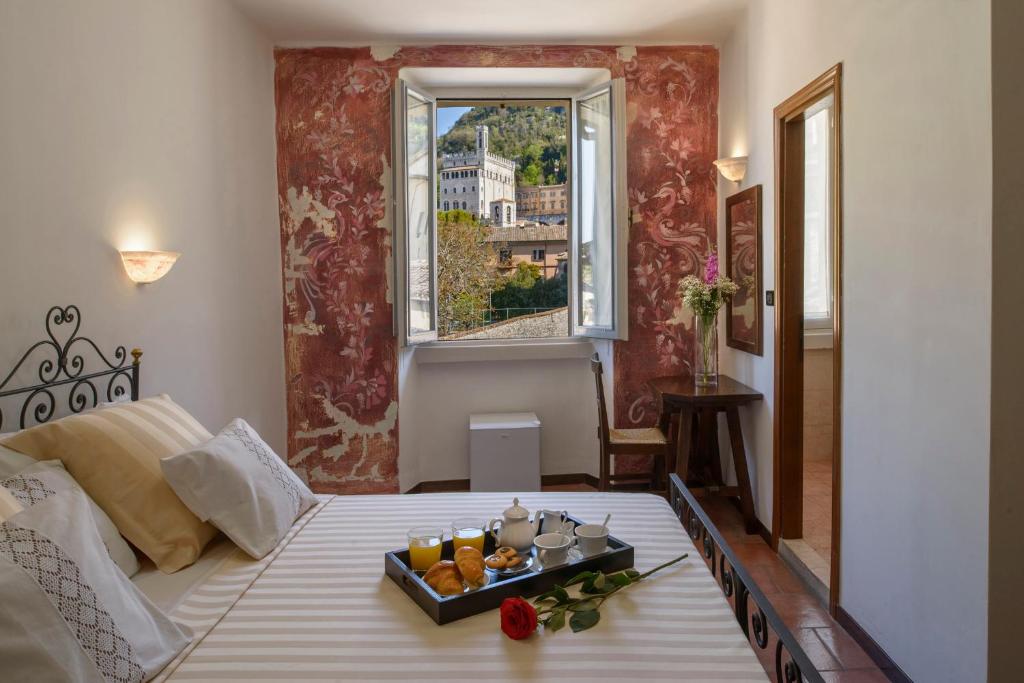 Un dormitorio con una cama con una bandeja de fruta. en Hotel Porta Marmorea en Gubbio