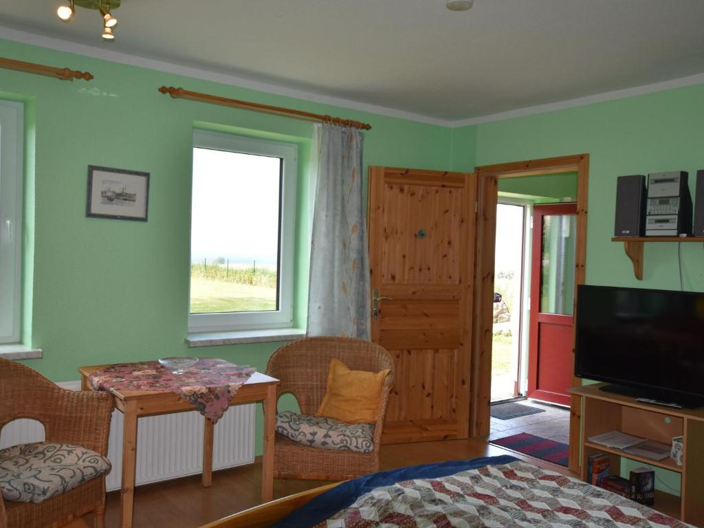 BastorfにあるComfy Holiday Home in Bastorf with Sea Viewのベッドルーム(ベッド1台、テーブル、テレビ付)