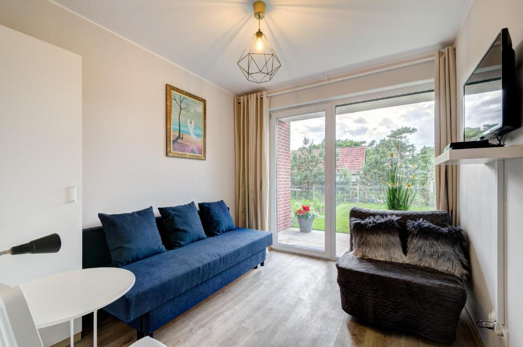 un soggiorno con divano blu e finestra di Apartament Jantar Park a Jantar