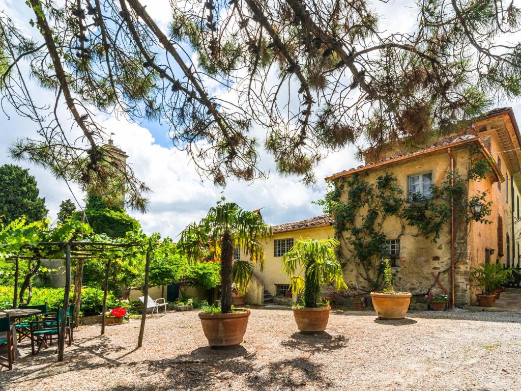 un cortile con piante in vaso e un edificio di Plush Farmhouse in Bacchereto with Swimming Pool a Carmignano