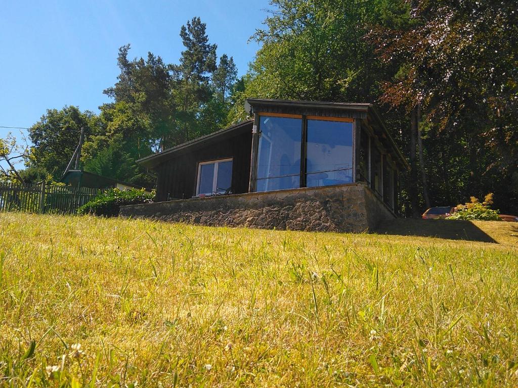 una casa sentada en la cima de un campo de hierba en Bungalow am Werratal Radwanderweg, en Breitungen
