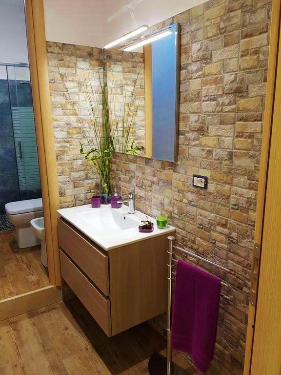 łazienka z umywalką i lustrem w obiekcie Corte Degli Aranci House w mieście Paterno