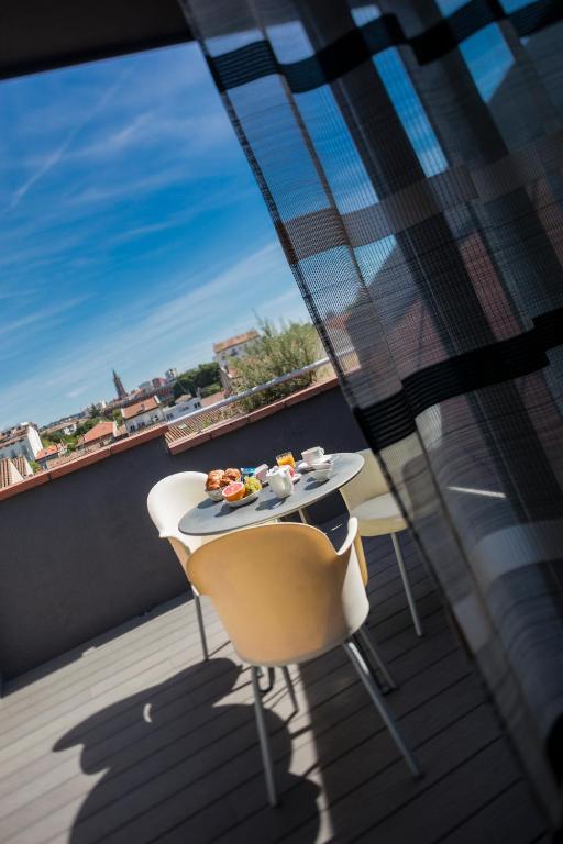 a table and chairs on a balcony with a view at Hôtel de Brienne in Toulouse
