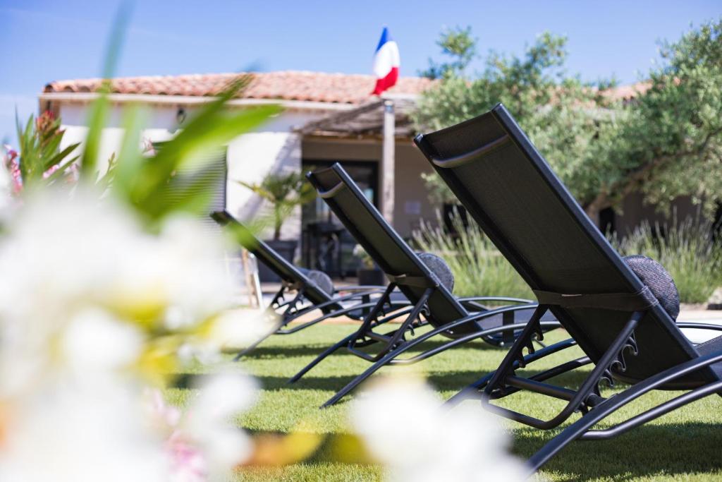 a row of lawn chairs sitting in the grass at les costebelles in Valensole