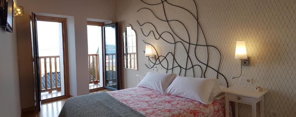 1 dormitorio con 1 cama con obras de arte en la pared en A Casiña de Dina, en Finisterre