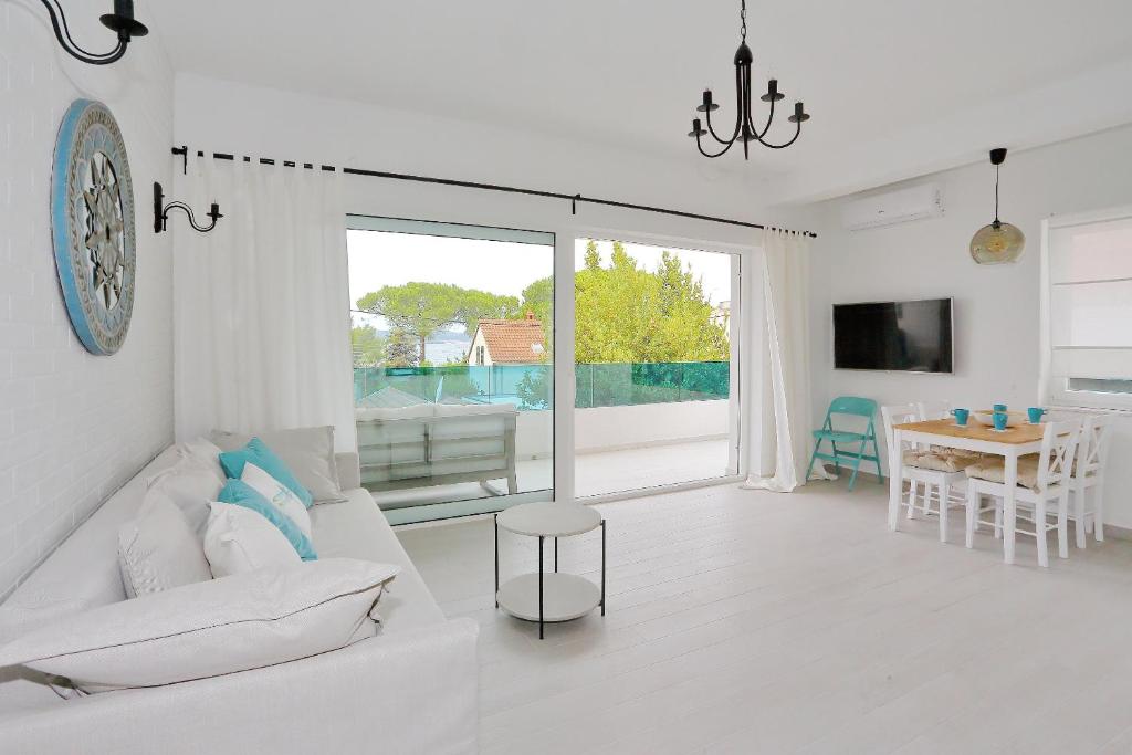een witte woonkamer met een witte bank en een tafel bij Villa Maris in Bibinje