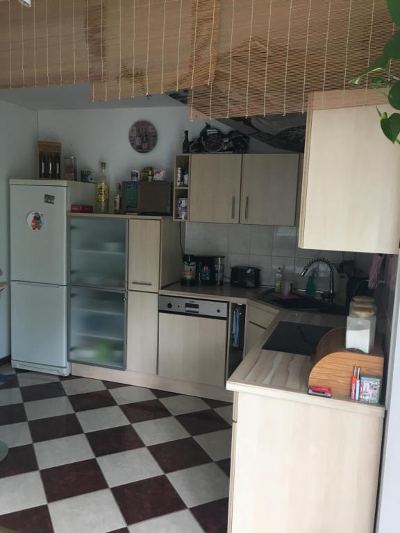 a kitchen with white appliances and a checkered floor at FeWo s Runde Wiese RW in Greifswald