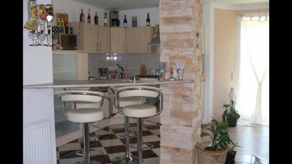 a kitchen with two bar stools in front of a counter at FeWo s Runde Wiese RW in Greifswald