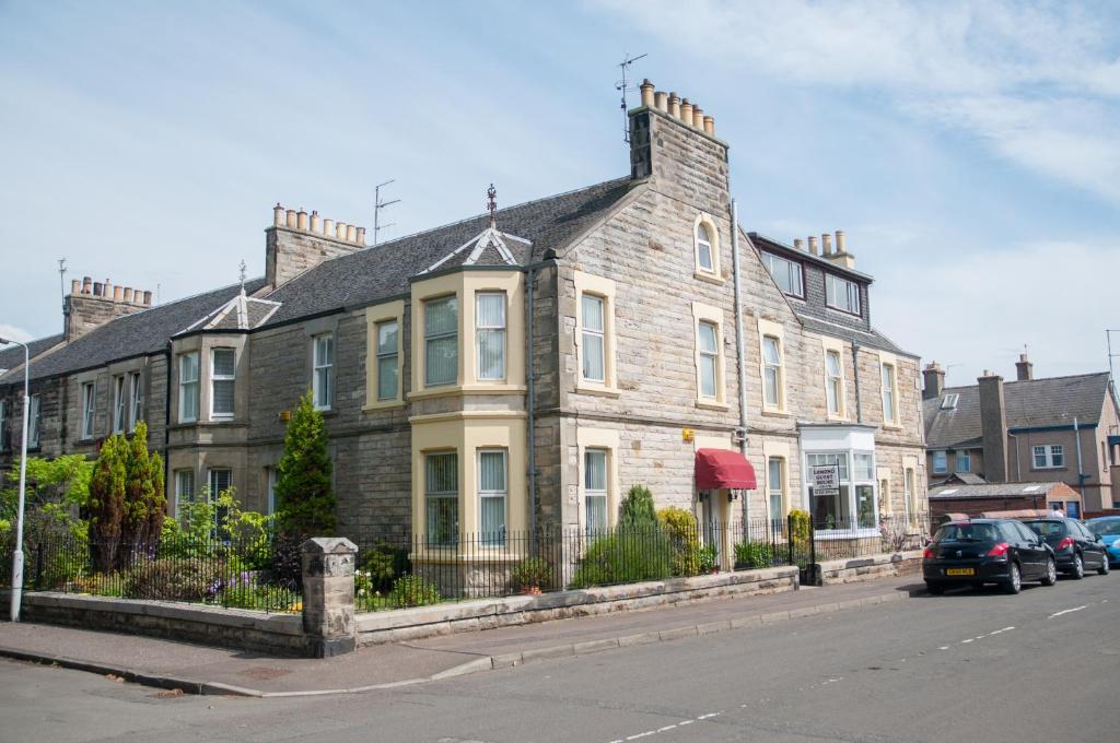 a large brick house on the side of a street at Lomond Guest House in Leven