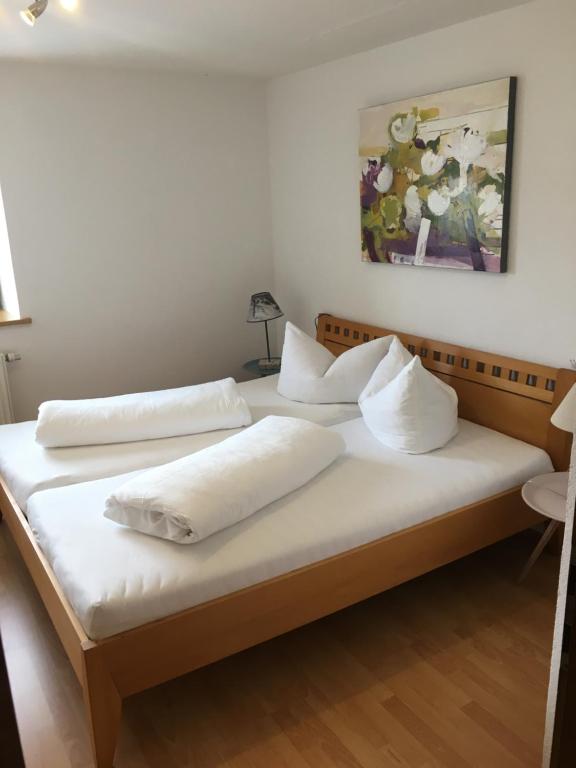 2 camas en una habitación con sábanas y almohadas blancas en Ferienwohnung Lech, en Pflach