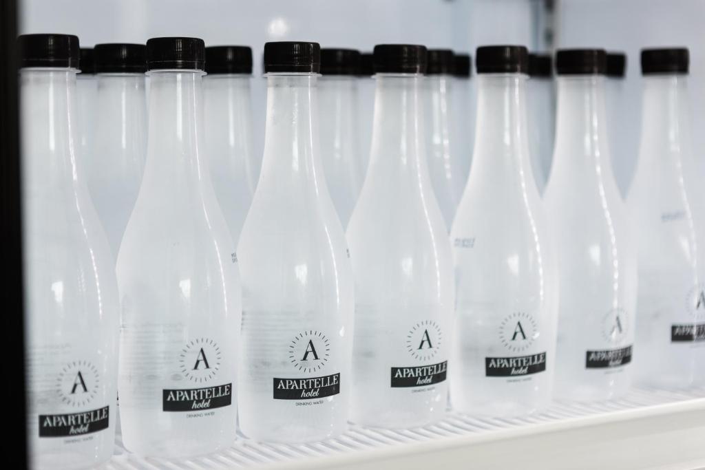 Rows of branded bottled water displayed on a shelf.