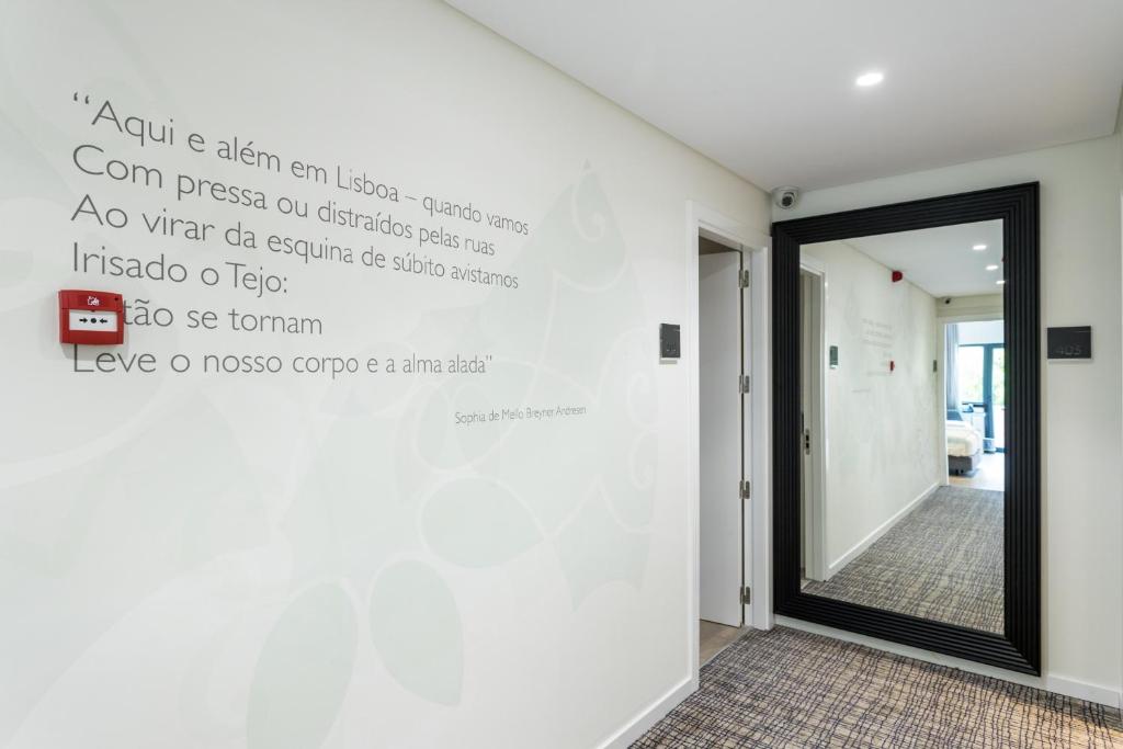 une chambre dotée d'un mur avec des écritures sur le mur dans l'établissement Hotel Capital Lisboa, à Lisbonne