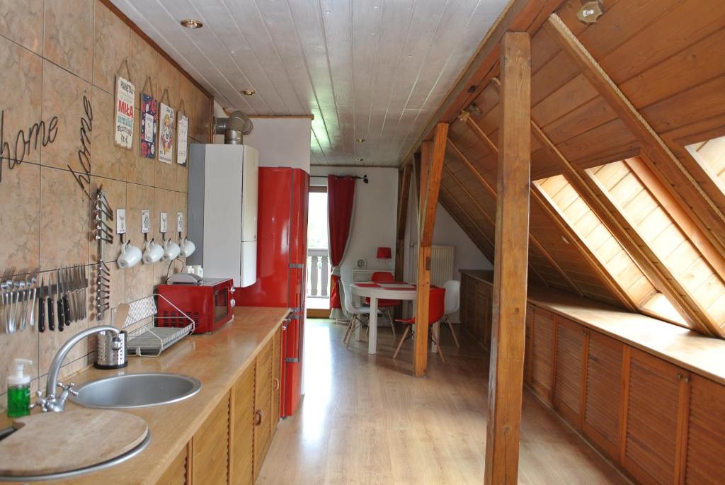 una cucina con frigorifero rosso e tavolo di Apartamenty EverySky - Wojska Polskiego 1-3 a Kowary