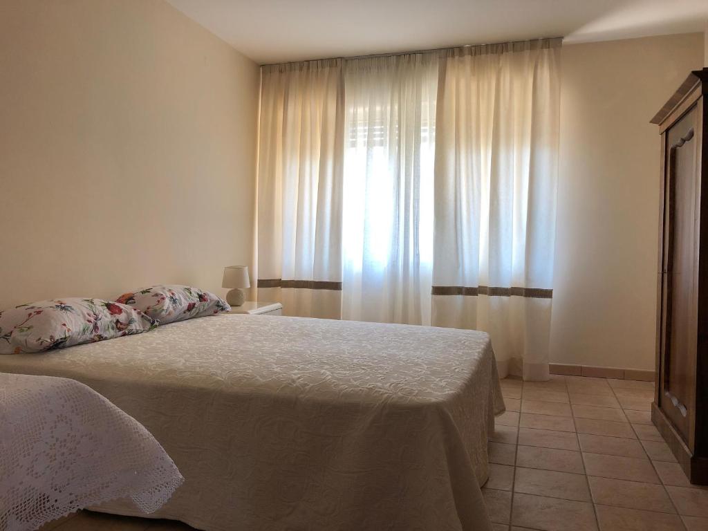 1 dormitorio con 1 cama y una ventana con cortinas en Magnolia en Pula