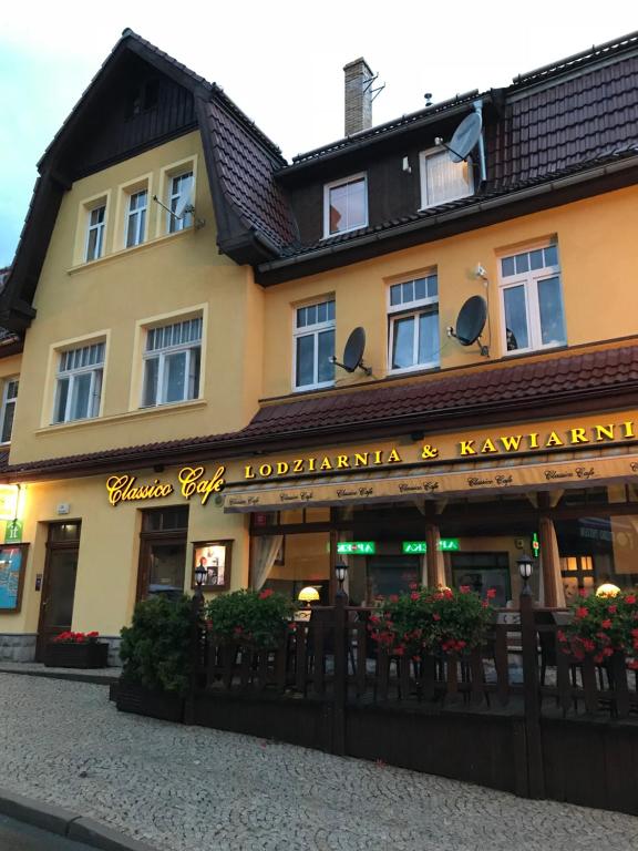 un bâtiment avec une enseigne sur la façade dans l'établissement Apartamenty Classico na deptaku, à Karpacz