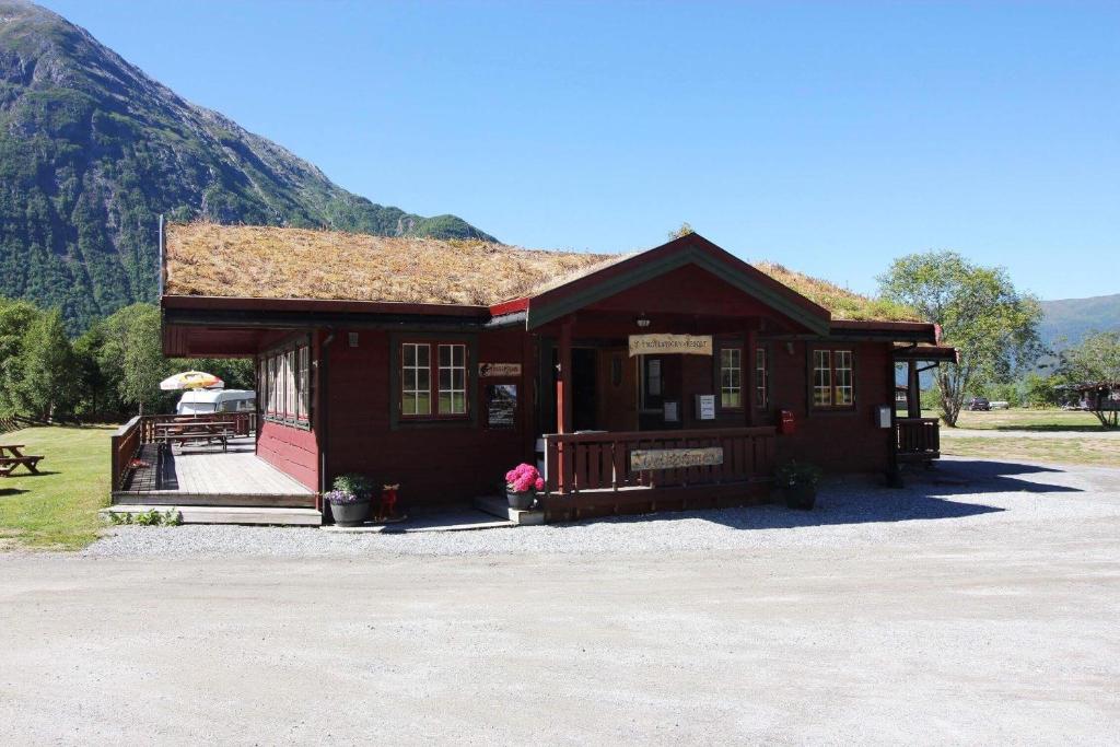 a small wooden building with a mountain in the background at Trollstigen Resort in Åndalsnes