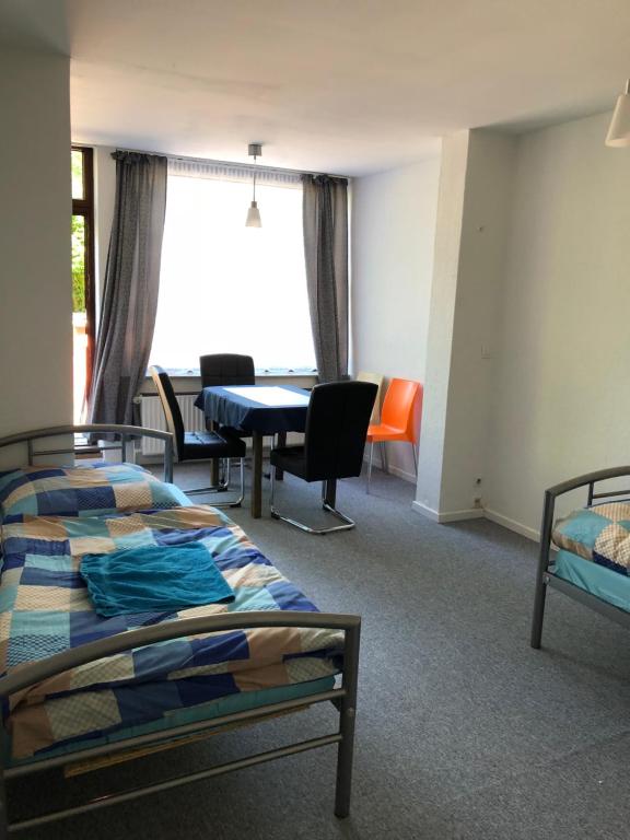 een kamer met 2 bedden en een tafel en stoelen bij Rana's Zimmervermittlung 2 in Bremen