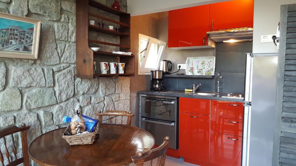 a kitchen with a wooden table and red cabinets at Résidence Di A Serra in Calvi
