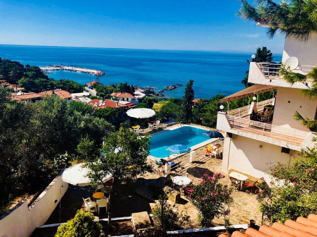 a view of a resort with a swimming pool and the ocean at Rooms Olympia in Gialiskari