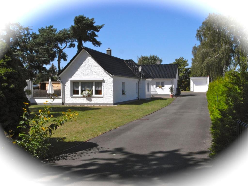 a white house with a driveway at Ferienhaus Schmidt in Storkow