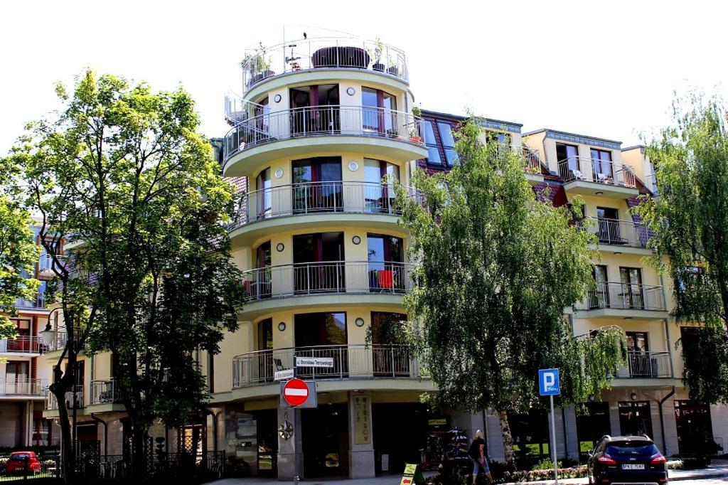 un edificio amarillo con balcones en un lateral en Rosa Weneda by Baltic Home en Świnoujście