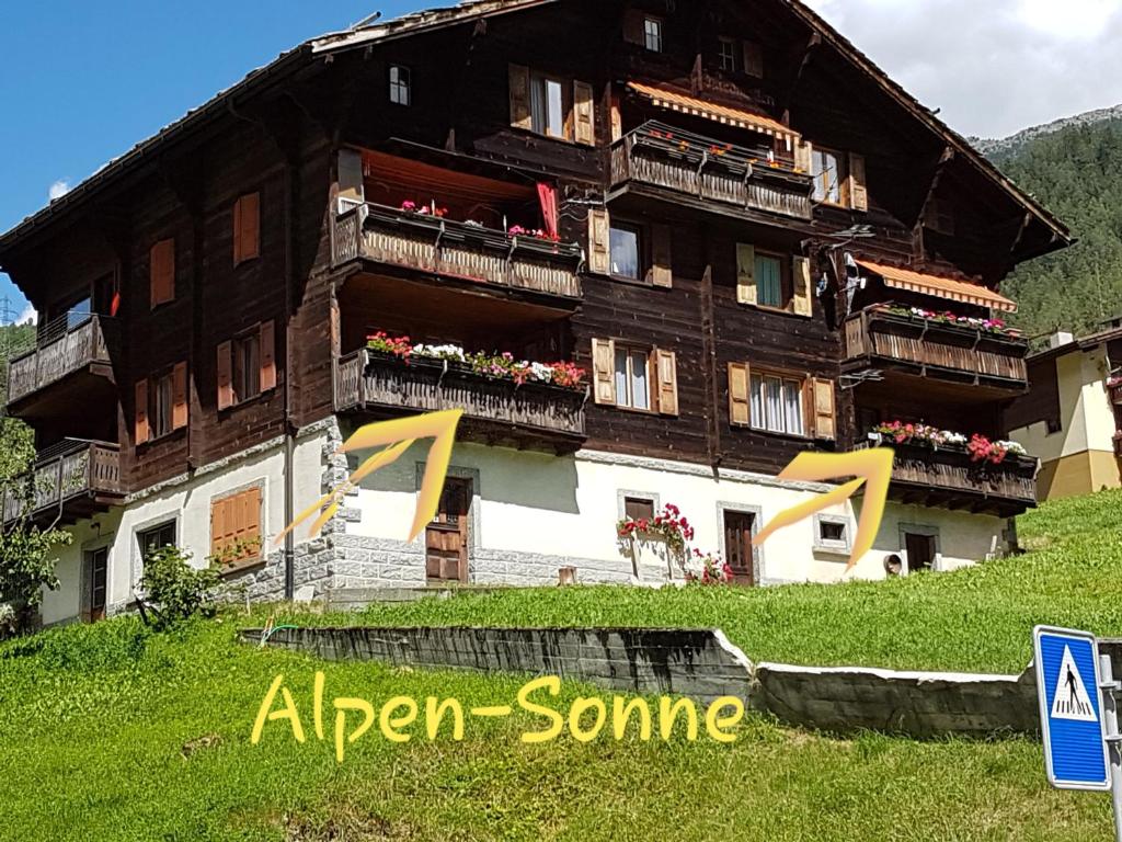 a building on a hill with the words afren some at Alpen-Sonne in Sankt Niklaus