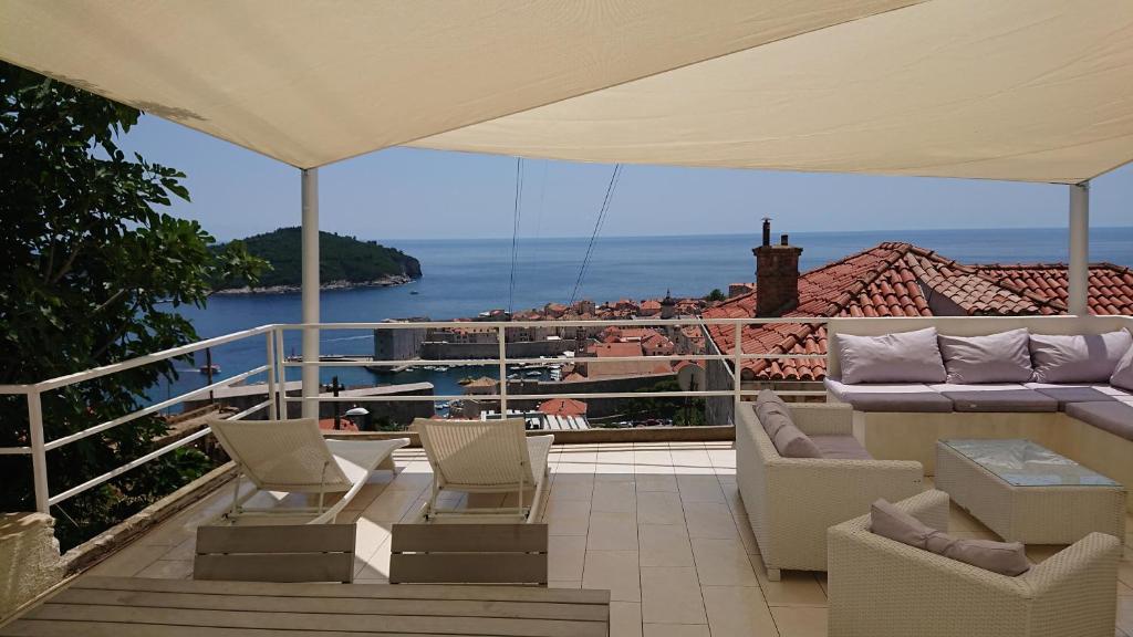 patio con sillas y balcón con cama en Apartment Chic Ploce, en Dubrovnik