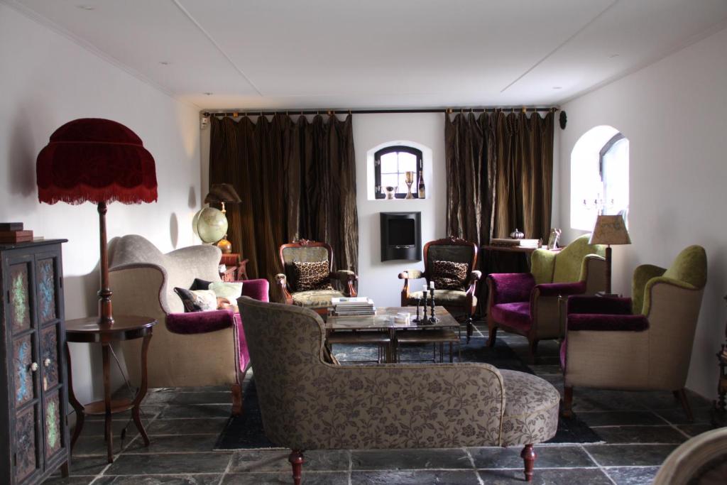 un soggiorno con divani, sedie e tavolo di Villa Gina Österlen a Sankt Olof