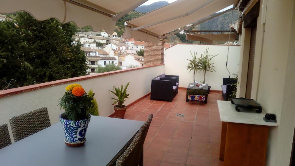 einen Balkon mit einer Blumenvase auf dem Tisch in der Unterkunft Apartamento Terrazas de Monachil in Monachil