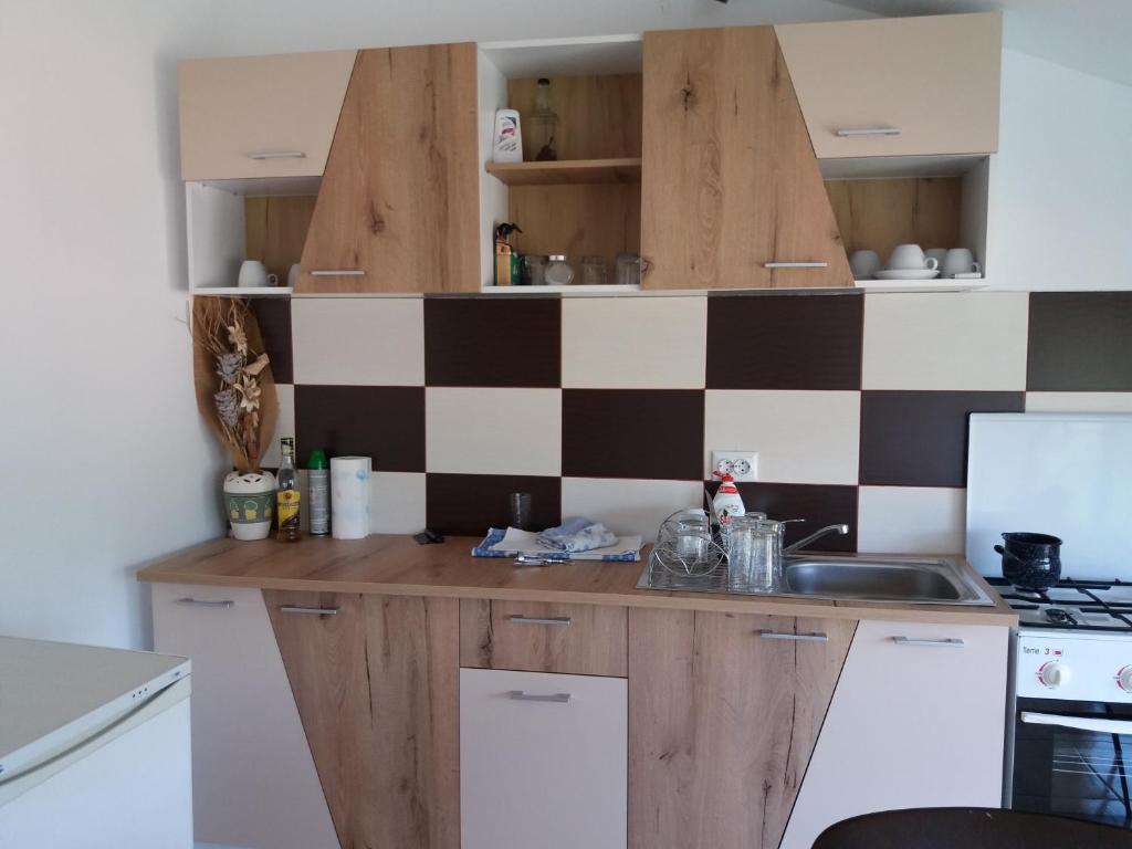 a kitchen with a checkered wall at Casa Raul in Coramnic