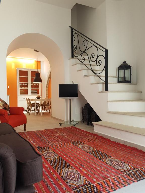 a living room with a staircase with a red rug at Casa Da Ponte in Estói