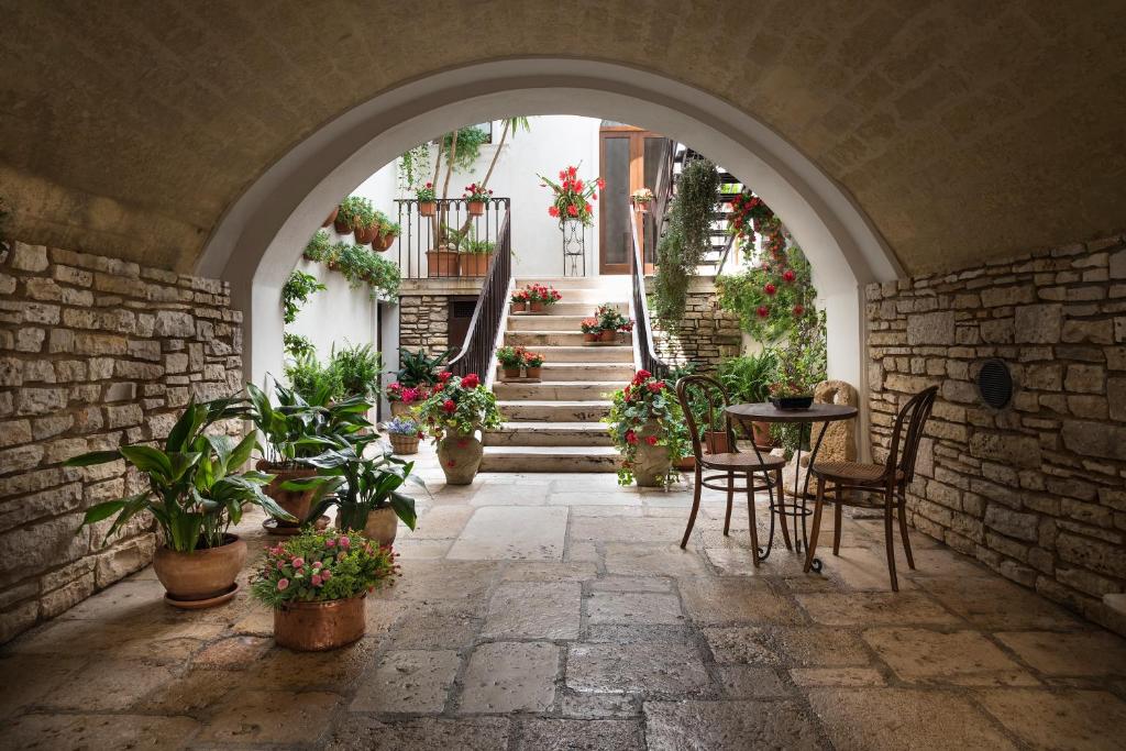 an archway with a table and chairs and potted plants at Malandrì in Altamura