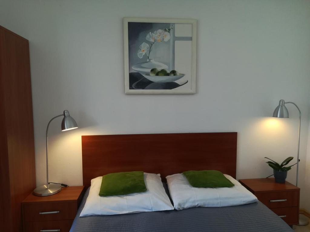 ジビジノにあるPokoje Goscinne Kamakoのベッドルーム1室(ランプ2つ、写真付)