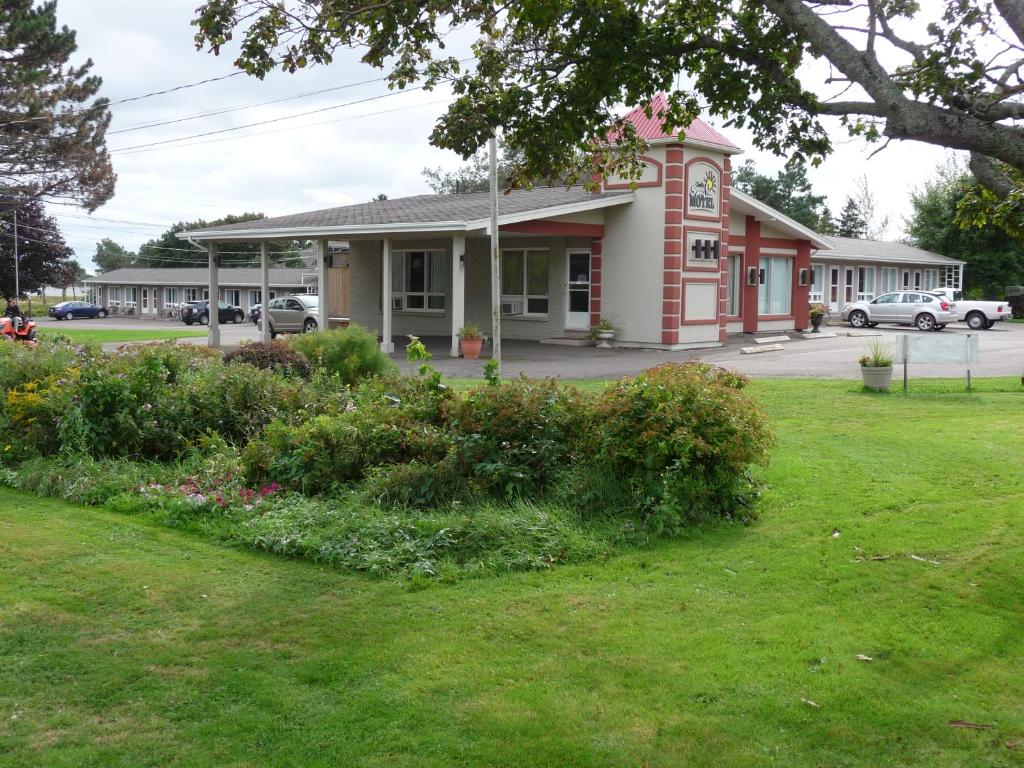 a building with a green yard in front of a building at Sunny Isle Motel in Summerside