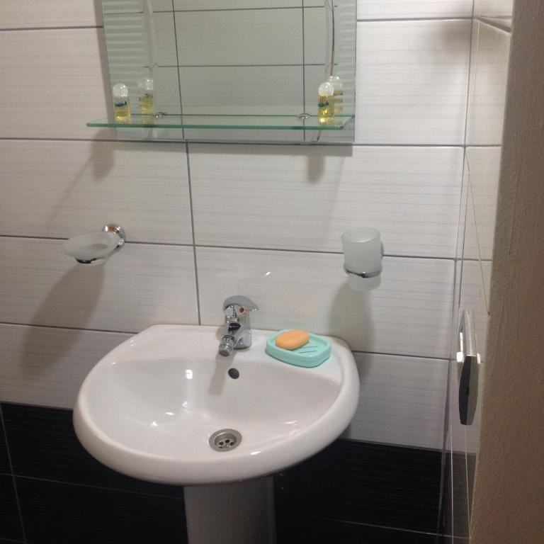 un bagno con un lavandino bianco e uno specchio di Guest house PANORAMA a Theth