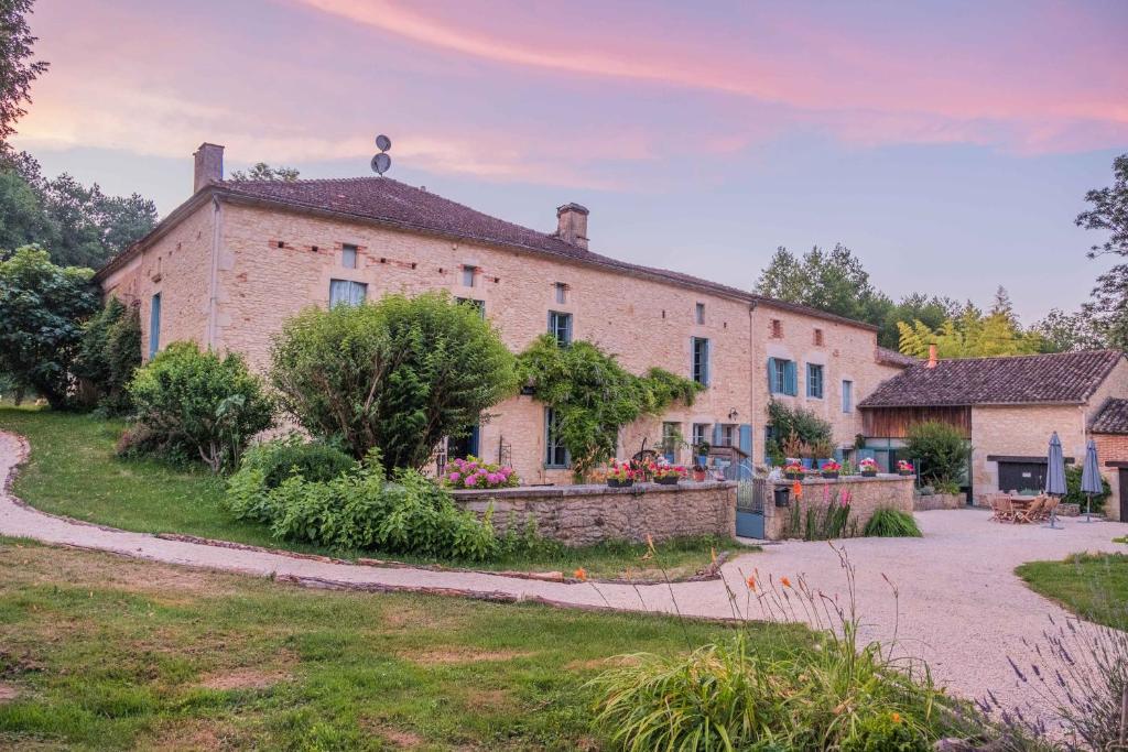 a large brick house with a garden in front of it at Moulin de Saint Avit in Gavaudun