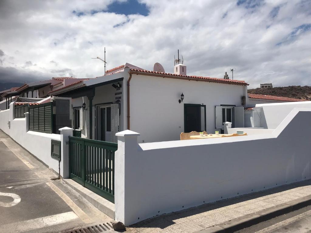 a white house with a white fence at Virgen del Carmen in Abades