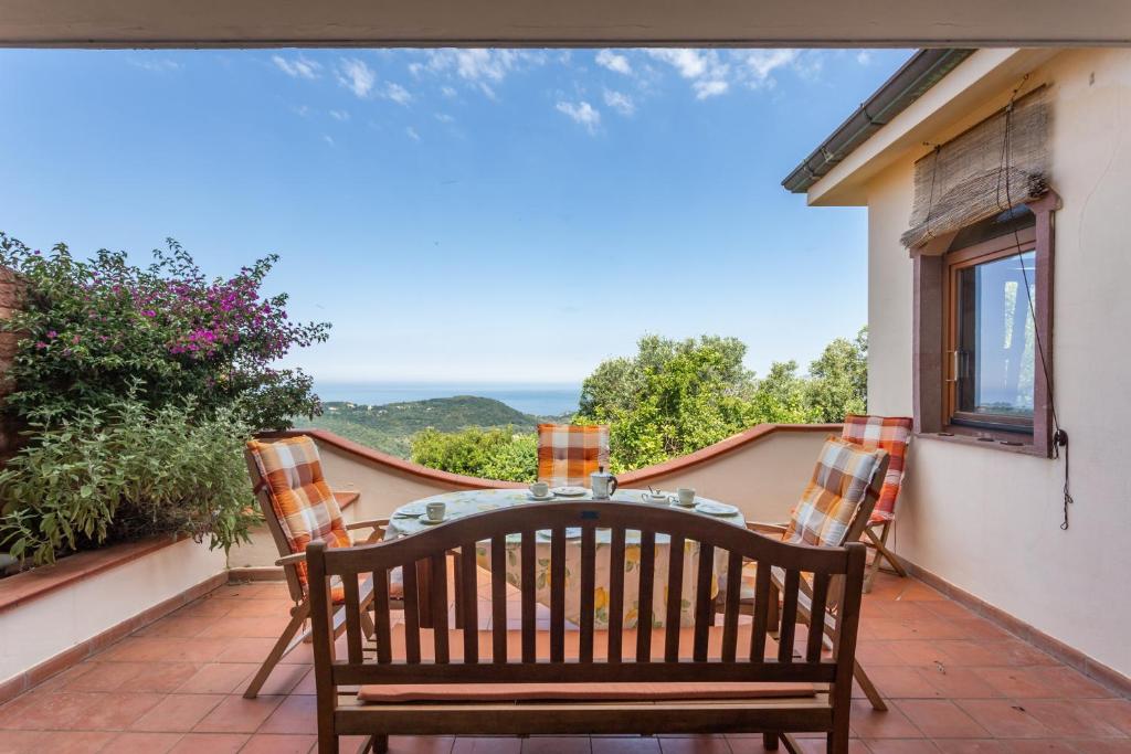 patio con mesa y sillas en el balcón en Casa Vista mare Bosa/Magomadas en Magomadas