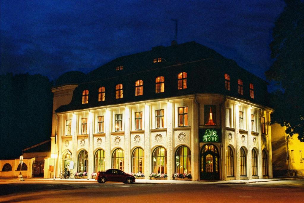 een groot gebouw met een auto voor de deur bij Hotel Victoria in Pärnu