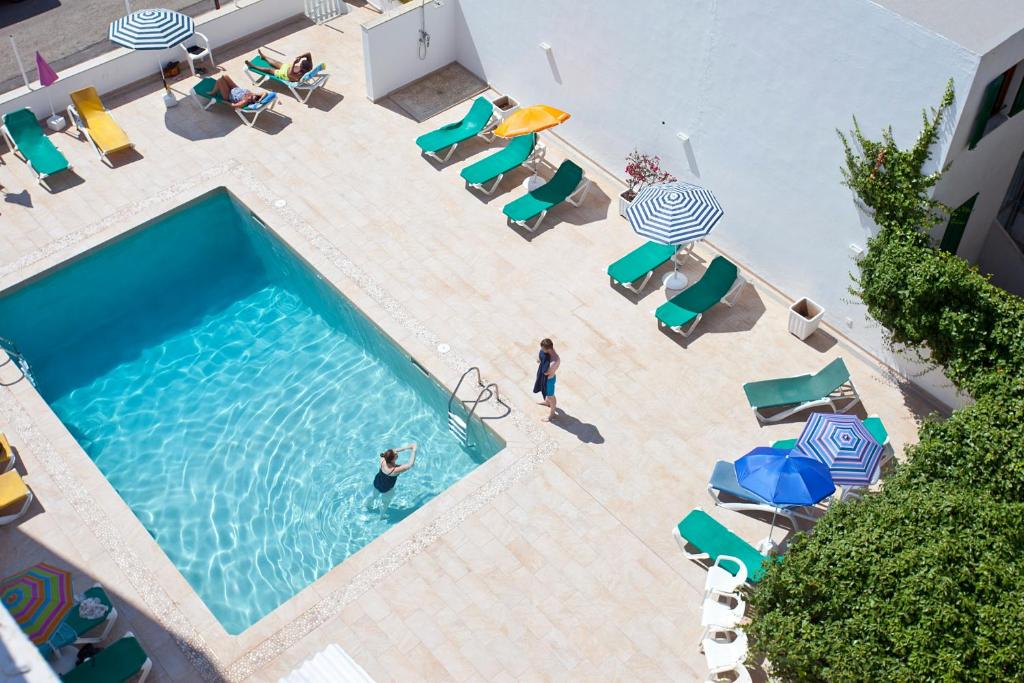 an overhead view of a swimming pool with chairs and umbrellas at Galaxia Boutique Hotel in Can Picafort