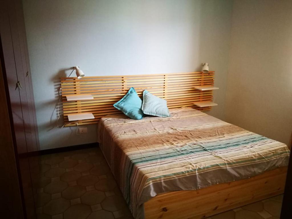una camera da letto con un letto con due cuscini blu sopra di La Praia 12 a Favignana
